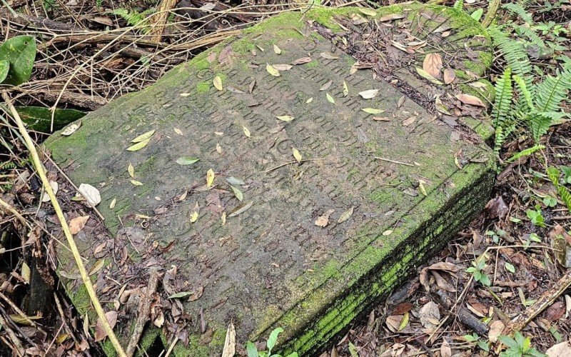 Resgate da lápide em meio ao mato onde foi encontrada