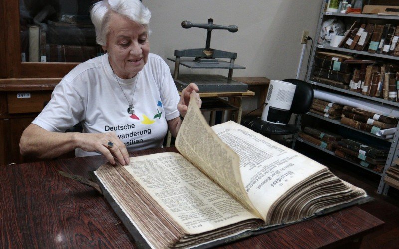 Ingrid mostra a bíblia de 1765 que não foi atingida pela inundação