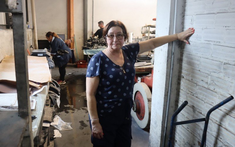 Na foto, Lenir Pereira mostra a altura em que a inundação alcançou dentro de sua indústria