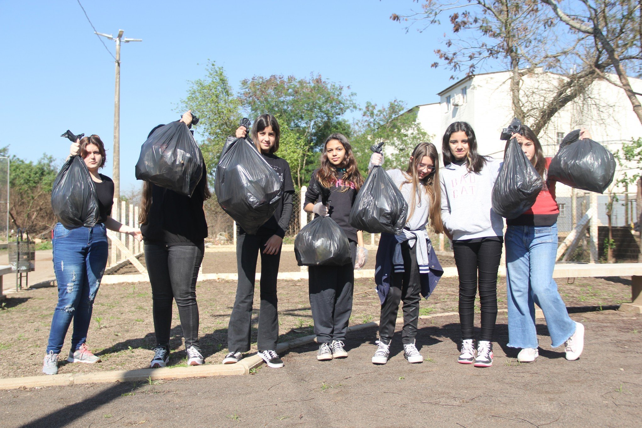 Estudantes limpam praça próxima à escola e que havia sido atingida pela enchente