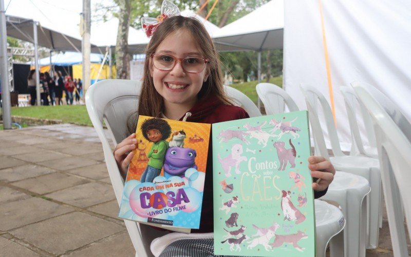 Alice escolheu o livro de um filme que ela gosta e outro sobre cachorros, por gostar de animais