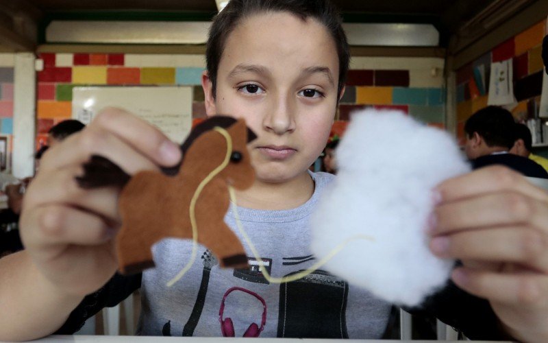 O aluno Mickael Tosetto Ferreira, 11 anos, mostra o cavalo de feltro e a espuma para preencher o chaveiro | abc+