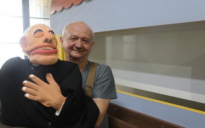 Padre Resende mostra o boneco de Padre Reus, que integra o teatro de fantoches da Missa com Crianças