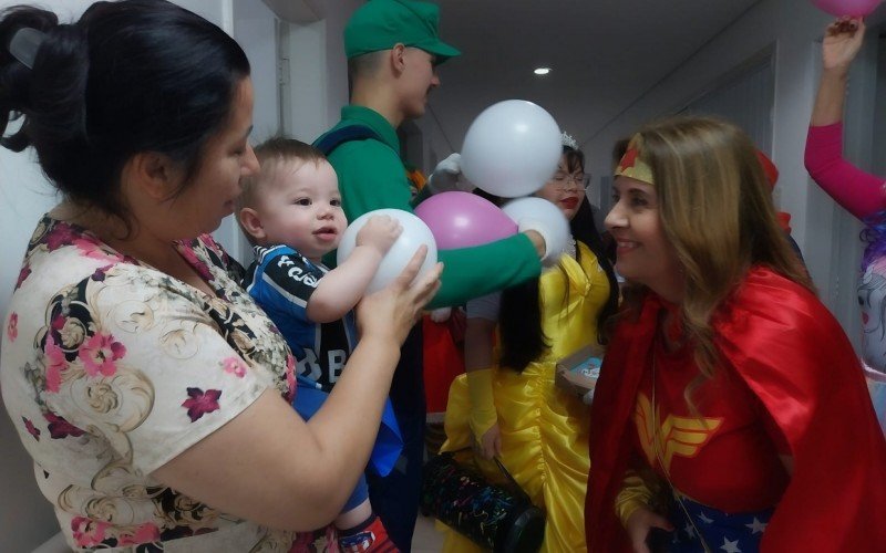  Caçadores de Sorriso: No colo da mãe, a professora Fabiana Oliveira, 35, Emanuel Cavalheiro, de 11 meses, não desgrudou do balão que recebeu dos personagens | abc+