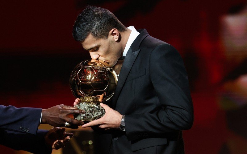 Meio-campista Rodri beijando o prêmio de melhor jogador do mundo | abc+