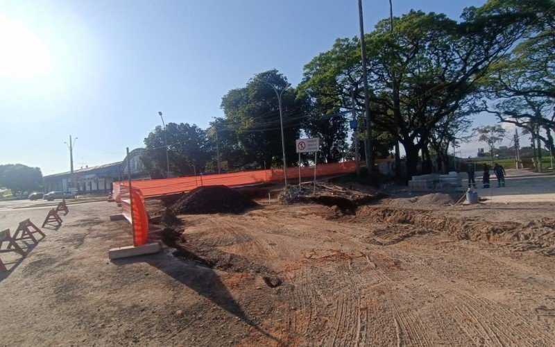 No local, as equipes estão finalizando o calçamento em pavs na alameda lateral da praça com a Avenida Caxias do Sul, além de realizar o nivelamento da pavimentação asfáltica no entroncamento das vias públicas.