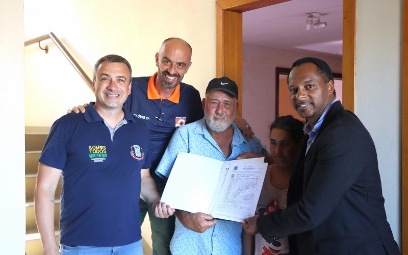 João e Rosângela Garcia mostram a escritura de sua nova casa junto ao vice-prefeito Cristiano Braatz, ao coordenador da Defesa Civil Clovis Pereira, e ao diretor da Secretaria de Reconstrução, Maister da Silva