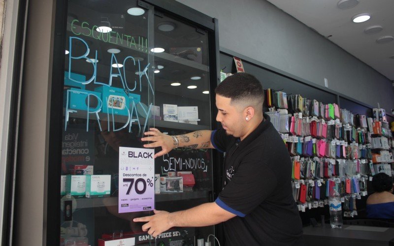 O gerente Lucas Gabriel Martins oferece descontos durante a Black Friday no Calçadão de Canoas