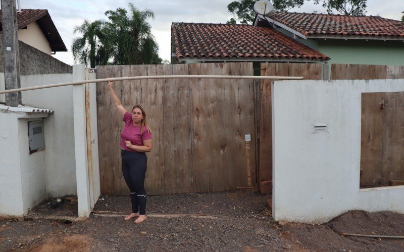 Fernanda mostra o desnivelamento do seu muro, resultado do afundamento do solo