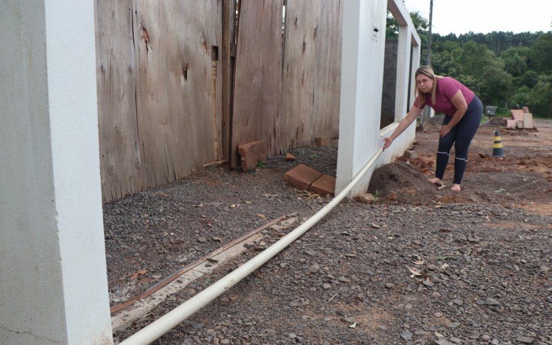 Fernanda mostra o desnivelamento do seu muro, resultado do afundamento do solo