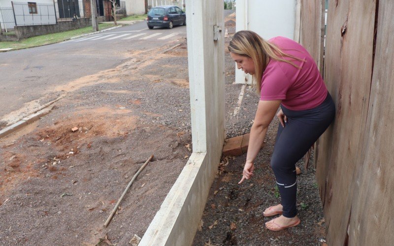 Fernanda mostra o desnivelamento do seu muro, resultado do afundamento do solo