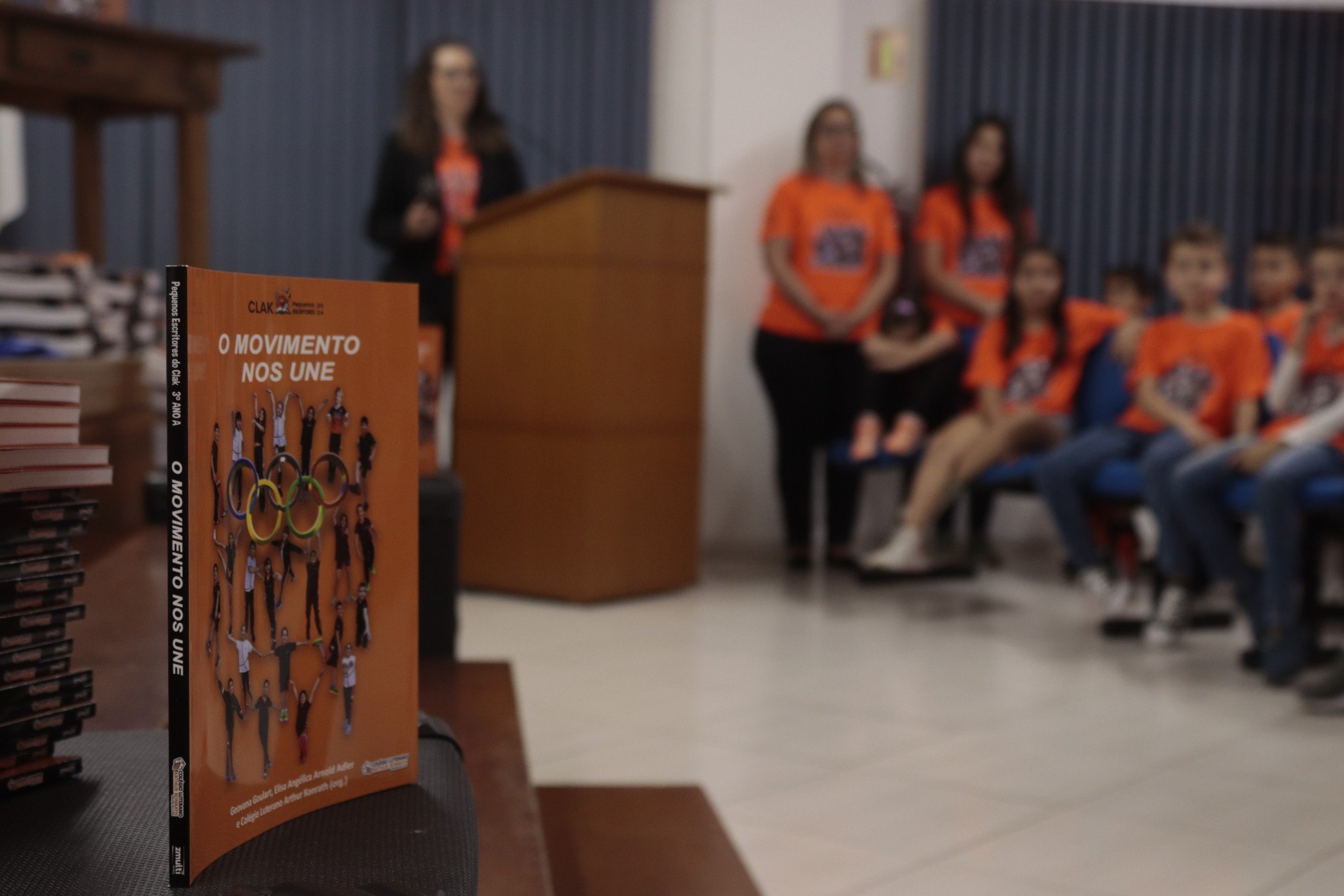 Estudantes do ensino fundamental autografam livros em atividade com familiares