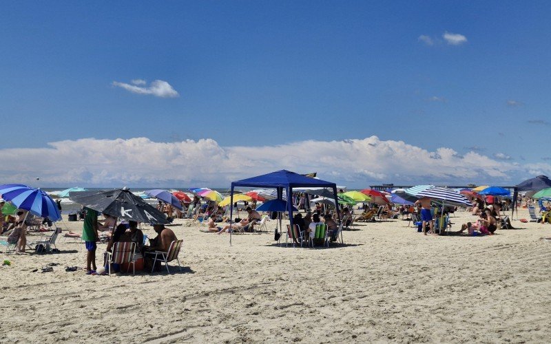 Mesmo com água mais escura, banhistas seguem aos montes na praia