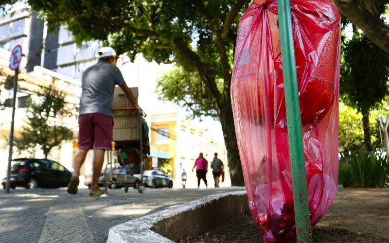 Sacos são improvisados para segurar o lixo em recipiente, na Praça da Emancipação, a poucos metros da Prefeitura de Canoas