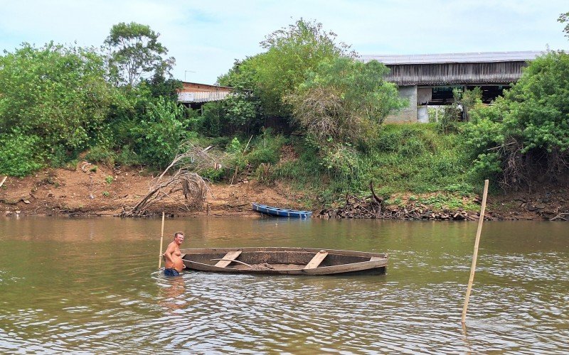 Moradores atravessam o rio caminhando