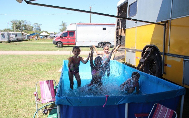 Criançada foge do calor com banhos de piscina e de mangueira