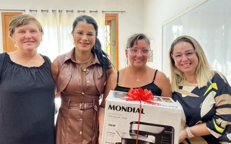 Carolina, a secretária Simone Dutra, Andréia e Patrícia na entrega do eletrodoméstico