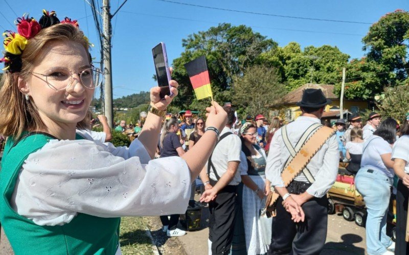 O Desfile Temático de Kerb - A Origem:  A técnica de enfermagem, Camila Schuh, 30 anos, que desfilaria no grupo da Igreja Evangélica de Confissão Luterana do Brasil (IECLB) marcou presença fotografando uma bandeira germânica | abc+