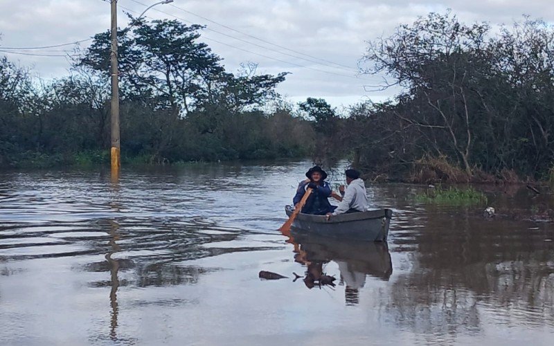 Somente de barco era possível acessar a Avenida Paquetá, na manhã deste sábado (21), em Canoas
