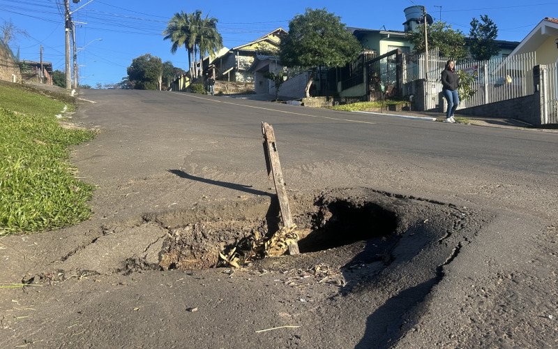 Na Rua Osvaldo Cruz, centro comercial do bairro Primavera, erosão fica no meio de uma lomba