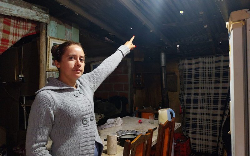 Moradora mostra danos causados em telhado de casa em Lindolfo Collor