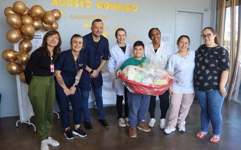 Equipe da USF Getúlio Vargas, do bairro Canudos, entregando o prêmio para Paula Gabriela e o filho Kaick | abc+