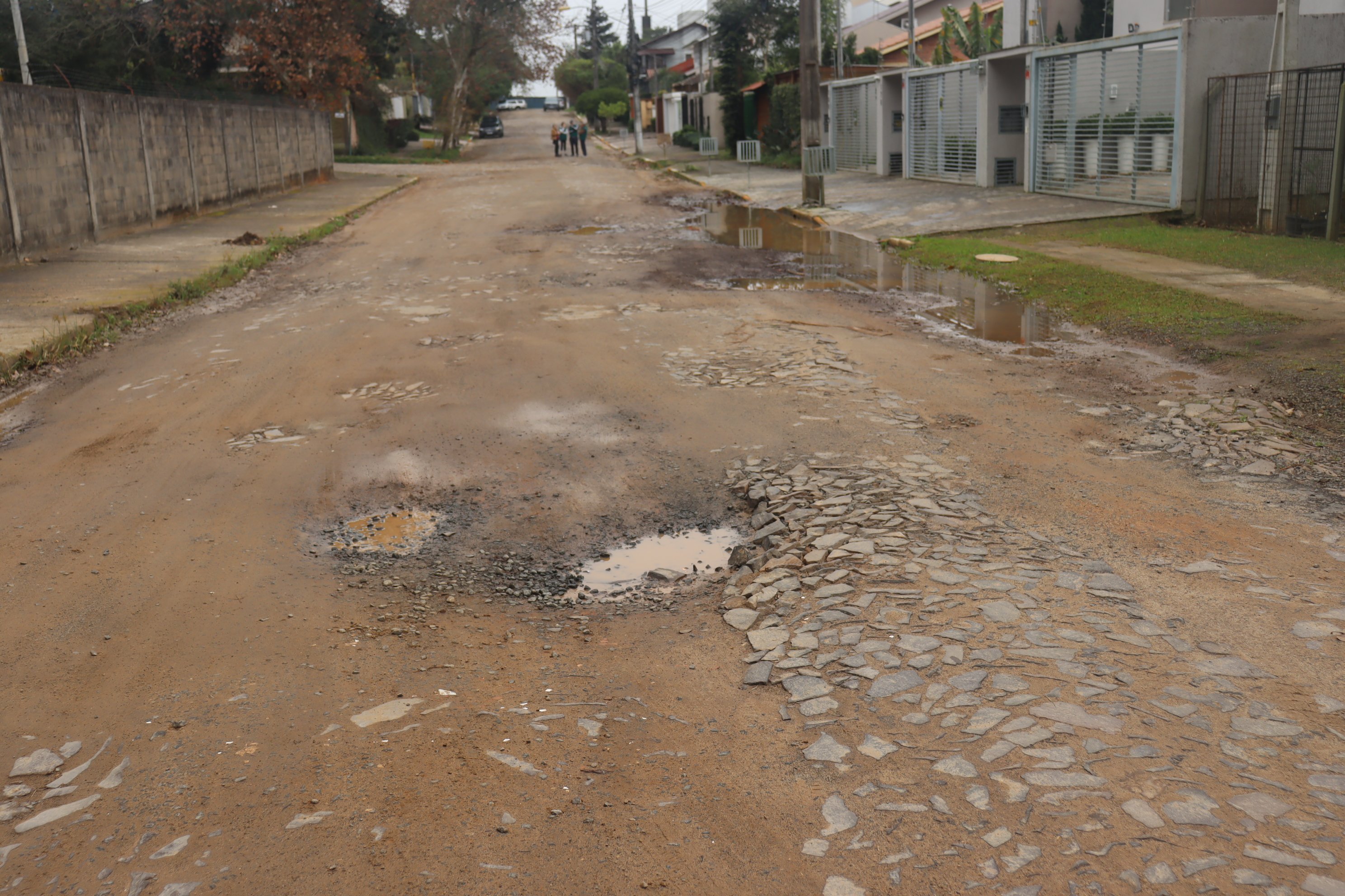 Em julho, Rua Regina Mundi cheia de buracos e terra