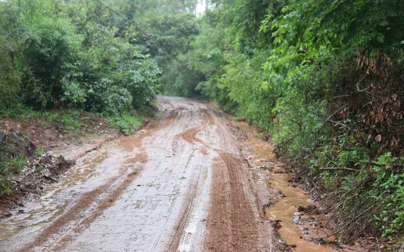 A estrada fica embarrada e dificulta o trânsito de carros e pedestres