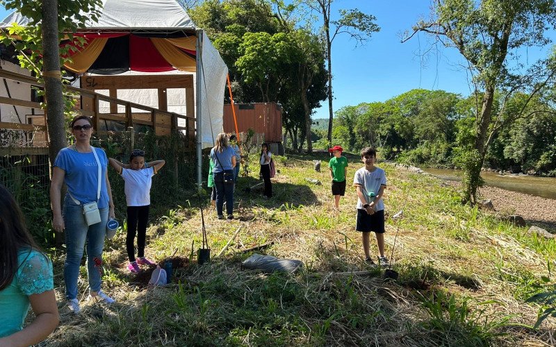 Estudantes de Igrejinha plantam árvores às margens do Rio Paranhana para ajudar na recuperação da encosta após as enchentes de 2024
