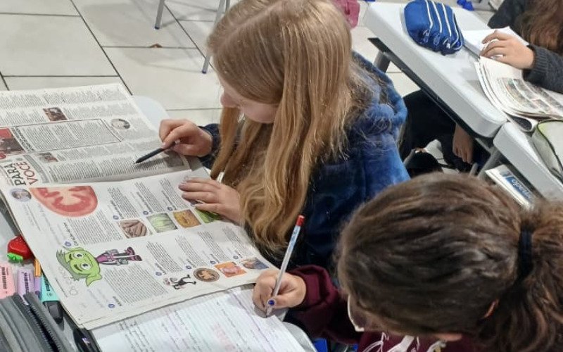 Alunos utilizam jornais para trabalhar em sala de aula