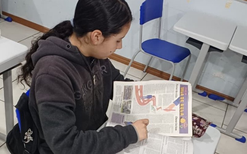 Alunos utilizam jornais para trabalhar em sala de aula
