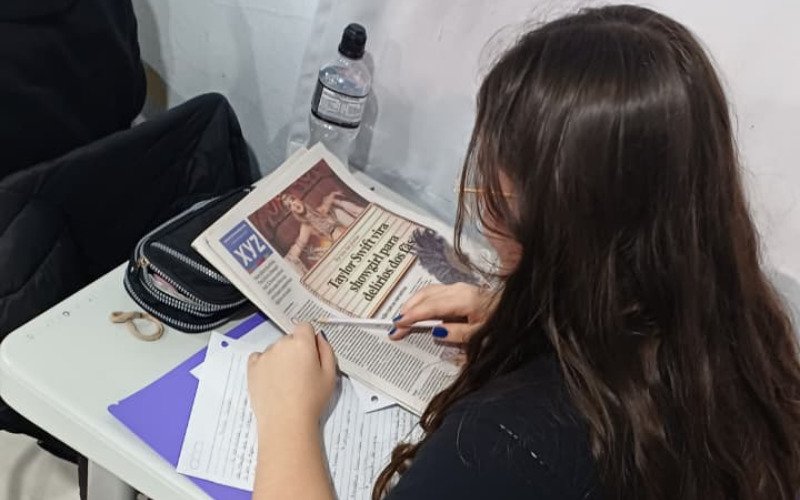 Alunos utilizam jornais para trabalhar em sala de aula