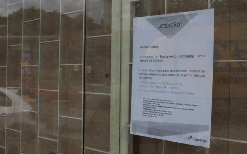 Aviso fixado na entrada informa que o atendimento foi transferido para a agência de Estância Velha. | abc+
