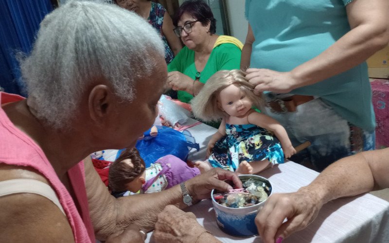 O Grupo de voluntárias arrumam as bonecas 