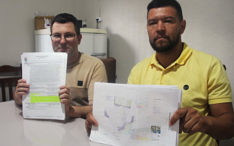 Anderson e Jonathan guardam documentos que falam sobre ações e enchentes na Vila Integração