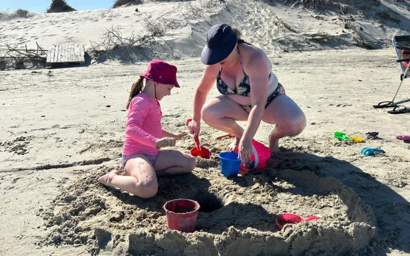 A pequena Isabelli Scholl ao lado da mãe Michele Kaeffer, de Santa Maria do Herval, montando um castelinho de areia | abc+