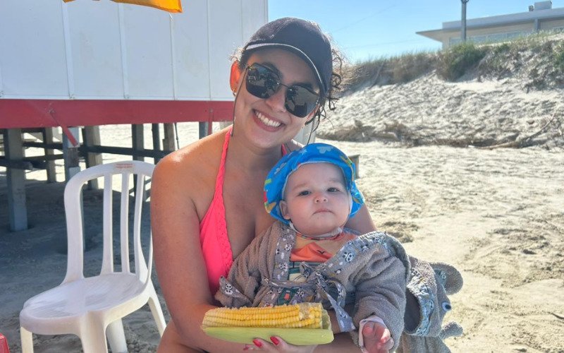 Aline Amorim Kaiser e o filho Theo, de Novo Hamburgo, não deixam de comer milho cozido na praia | abc+