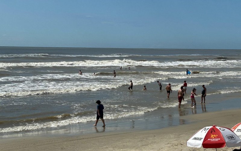 Mesmo com mar de ressaca, veranistas aproveitam a praia em Tramandaí