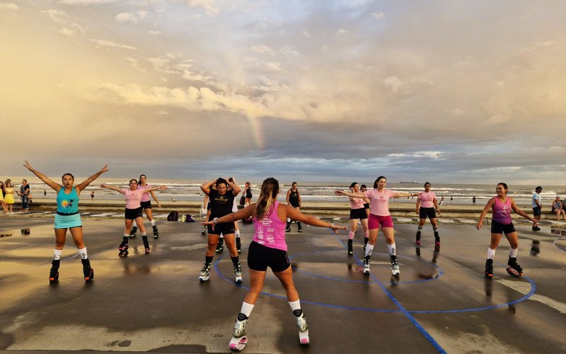 Fim do dia com arco-íris e sol se pondo é cenário para as aulas ao ar livre em Tramandaí