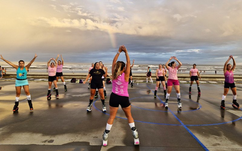 Fim do dia com arco-íris e sol se pondo é cenário para as aulas ao ar livre em Tramandaí