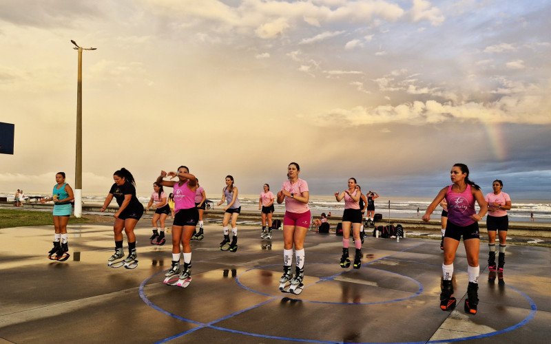 Fim do dia com arco-íris e sol se pondo é cenário para as aulas ao ar livre em Tramandaí
