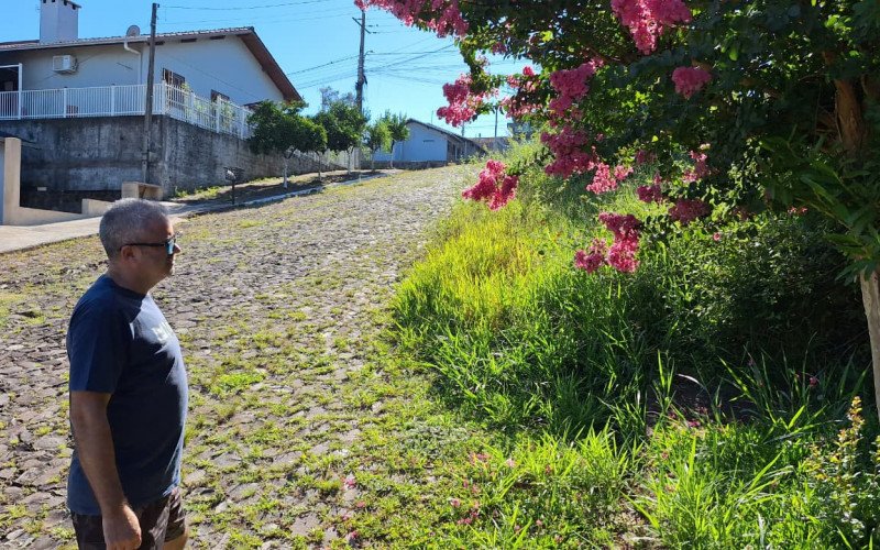 Empresário Sidnei Costa da Cruz contrata um jardineiro para fazer a roçada da rua em frente à sua residência, mas no restante da rua o mato toma conta da via  | abc+