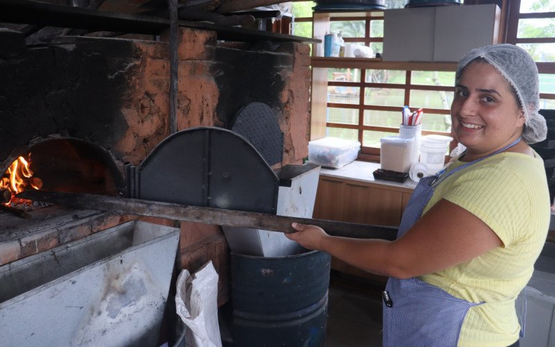 Fernanda Almeida prepara o fogo para assar as del&iacute;cias do Sabor da Col&ocirc;nia, em Sapiranga