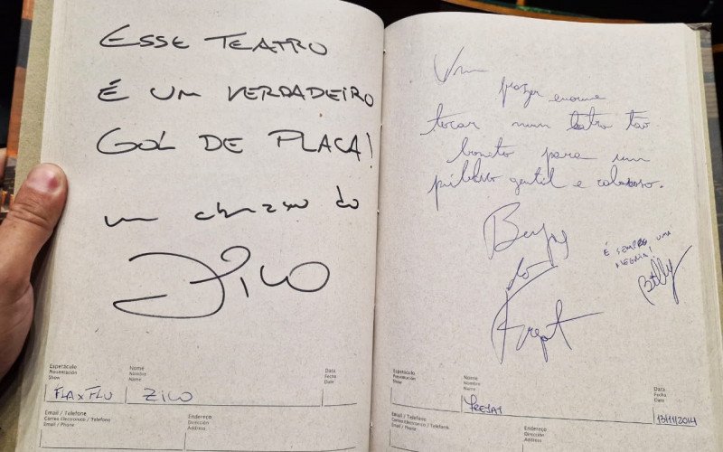 O jogador Zico e o músico Frejat lado a lado no livro de registros do Teatro Feevale