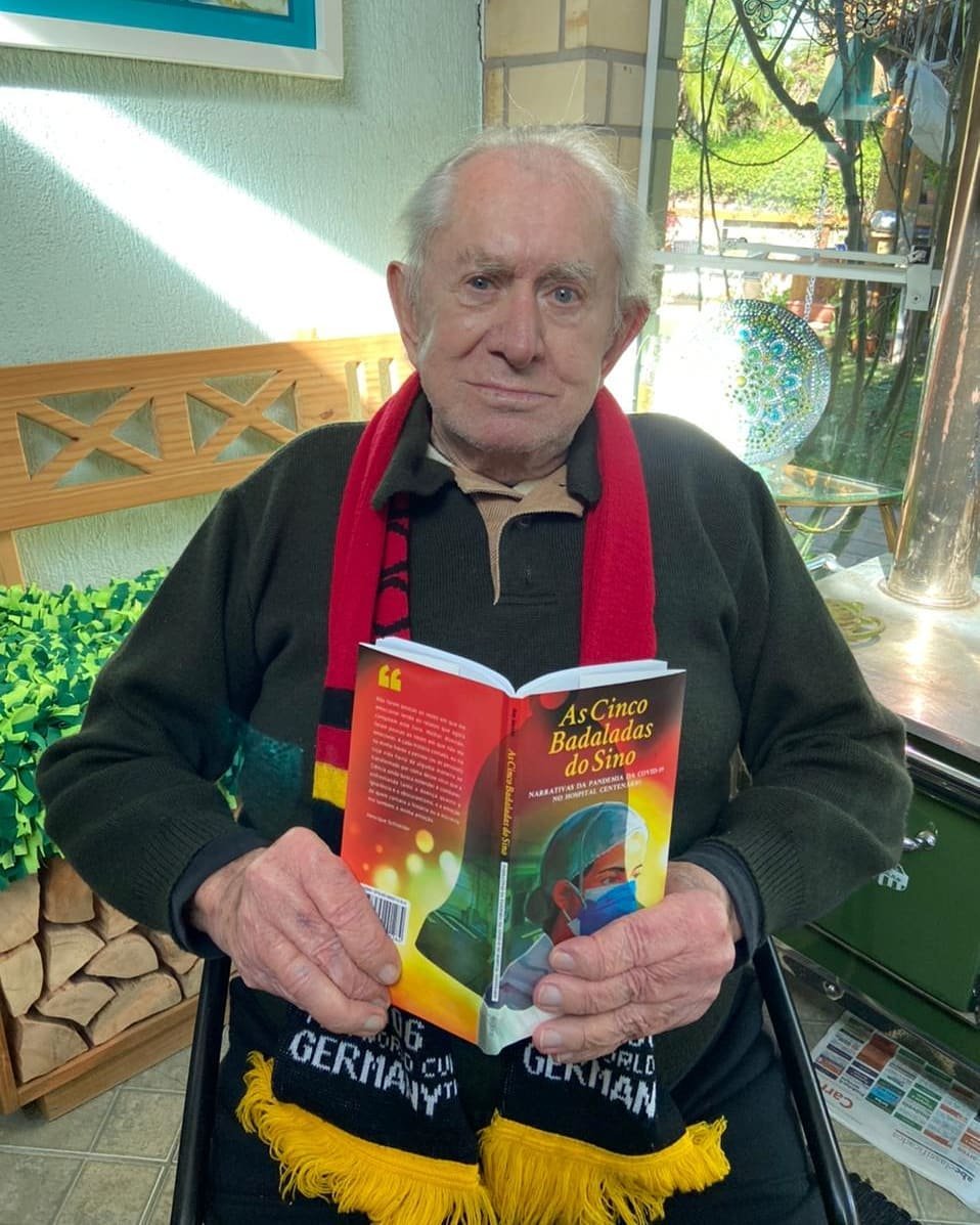 Registro de Édio Zang, com o livro As Cinco Badaladas do Sinos, de Anna Garske,  que trata do seu Sino da Vitória no Hospital Centenário