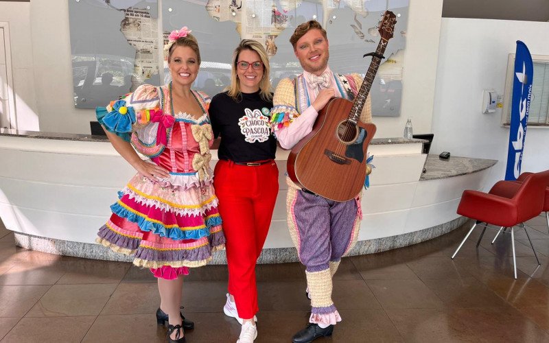 Carol Thoen e Alisson Ariel da Trupe da Páscoa e Kenia Jaeger, gerente da ChocoPáscoa, em visita ao Grupo Sinos | abc+