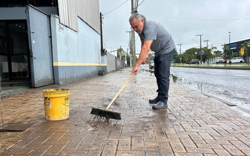 empresário Luís Picoli, 61 anos, dono de uma oficina mecânica, precisou recorrer a pá, vassoura e lava-jato para remover a crosta de barro acumulada na entrada do prédio e na calçada | abc+