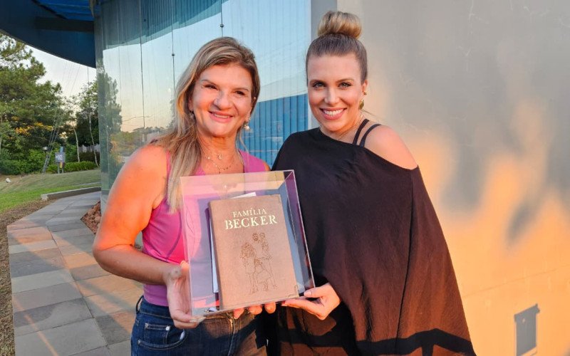 Magali Becker recebe de Stephanie Kichler, da Made in God, uma Bíblia personalizada produzida em homenagem ao goleiro Alisson Becker. | abc+