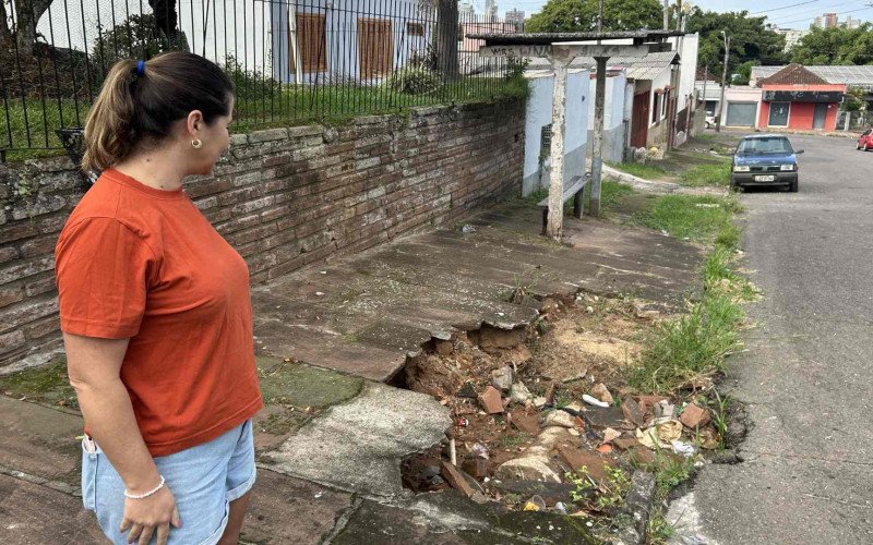 Ana Paula de Melo Martiny e a cratera existente em frente a sua casa há dois anos