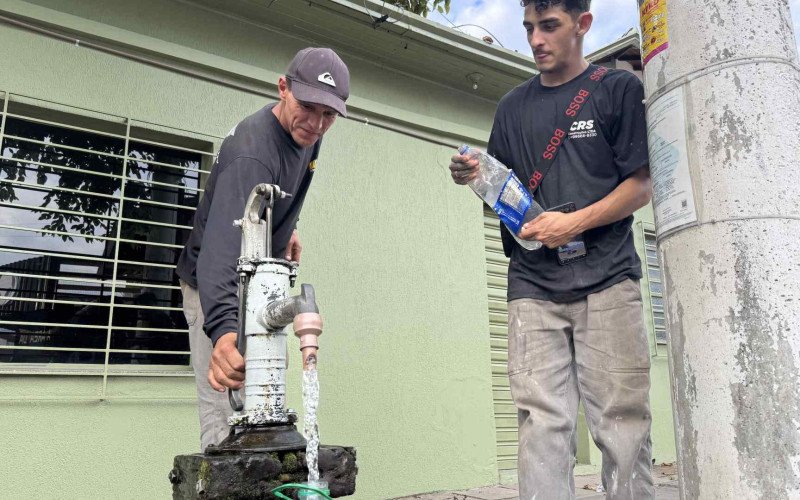 Mairo Santos dos Santos pega água da bica na Rua Rincão, no bairro Operário